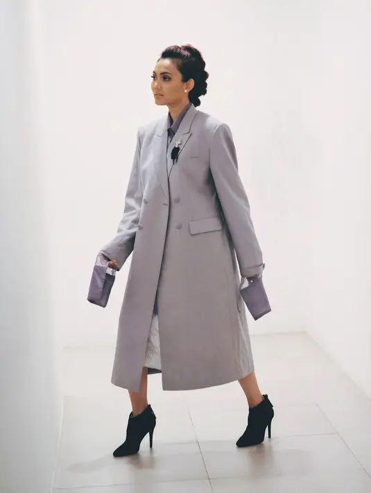 Kalau yang satu ini, Rina memakai long blazer berwarna abu-abu yang menyerupai dress. Kemudian, ia padukan dengan ankle boots heels berwarna hitam. Edgy banget gayanya yang satu ini. (Instagram/rinanose16)