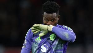 Kiper Manchester United, Andre Onana, menyeka wajahnya saat laga lanjutan Liga Inggris 2024/2025 melawan Newcastle yang berlangsung di Old Trafford, Manchester, Inggris, Selasa (31/12/2024) WIB. (AFP/Darren Staples)