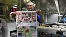 Andreas Schenk, salah satu petugas percetakan surat kabar "Bild", menunjukkan halaman depan yang berisi foto selebrasi pemain tengah Timnas Jerman, Mario Goetze, (14/7/2014). (REUTERS/Fabian Bimmer)
