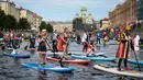 Sejumlah peserta mengenakan kostum mendayung papan Stand Up Paddle (SUP) di kanal Kryukov saat Surfing festival di St.Petersburg, Rusia (8/7). Olahraga ini tidak hanya dimainkan di laut saja, tetapi bisa disungai atau danau. (AP Photo / Dmitri Lovetsky)