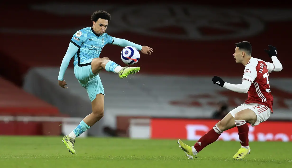 Pemain Arsenal Gabriel Martinelli (kanan) menghalau pemain Liverpool Trent Alexander-Arnold pada pertandingan Liga Inggris di Emirates Stadium, London, Inggris, Sabtu (3/4/2021). Liverpool membantai Arsenal dengan skor 3-0. (Adam Davy/Pool via AP)