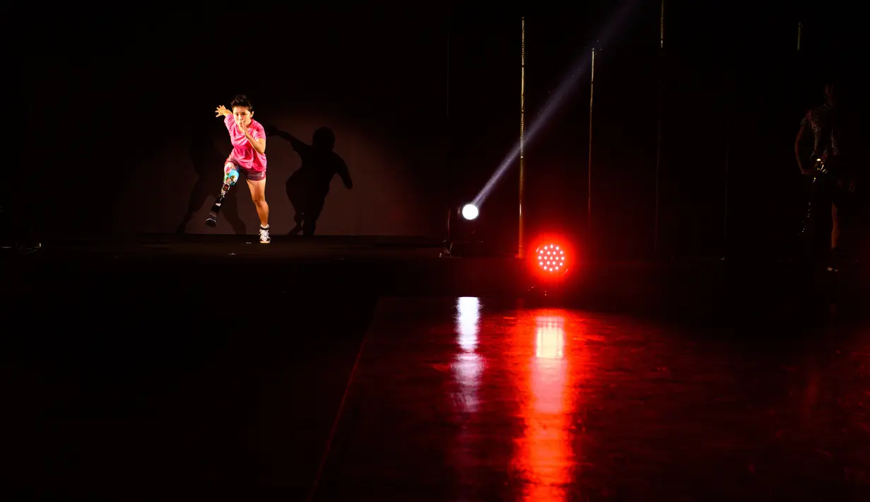 Atlet Hitomi Onishi menampilkan kreasi desainer Makiko Sugawa saat joging di catwalk dalam fashion show bertajuk "Amputee Venus Show" di Tokyo, Selasa (25/8/2020). Fashion show tersebut menandai pembukaan Paralympic Games yang rencananya akan dibuka pada 24 Agustus 2021 mendatang. (PPhilip FONG/AFP)