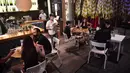 Pelayan melayani pelanggan di sebuah bar di Bangkok, Thailand, Rabu (1/7/2020). Mulai 1 Juli, bar di Bangkok kembali diizinkan buka setelah pengurangan pembatasan akibat COVID-19. (Lillian SUWANRUMPHA/AFP)