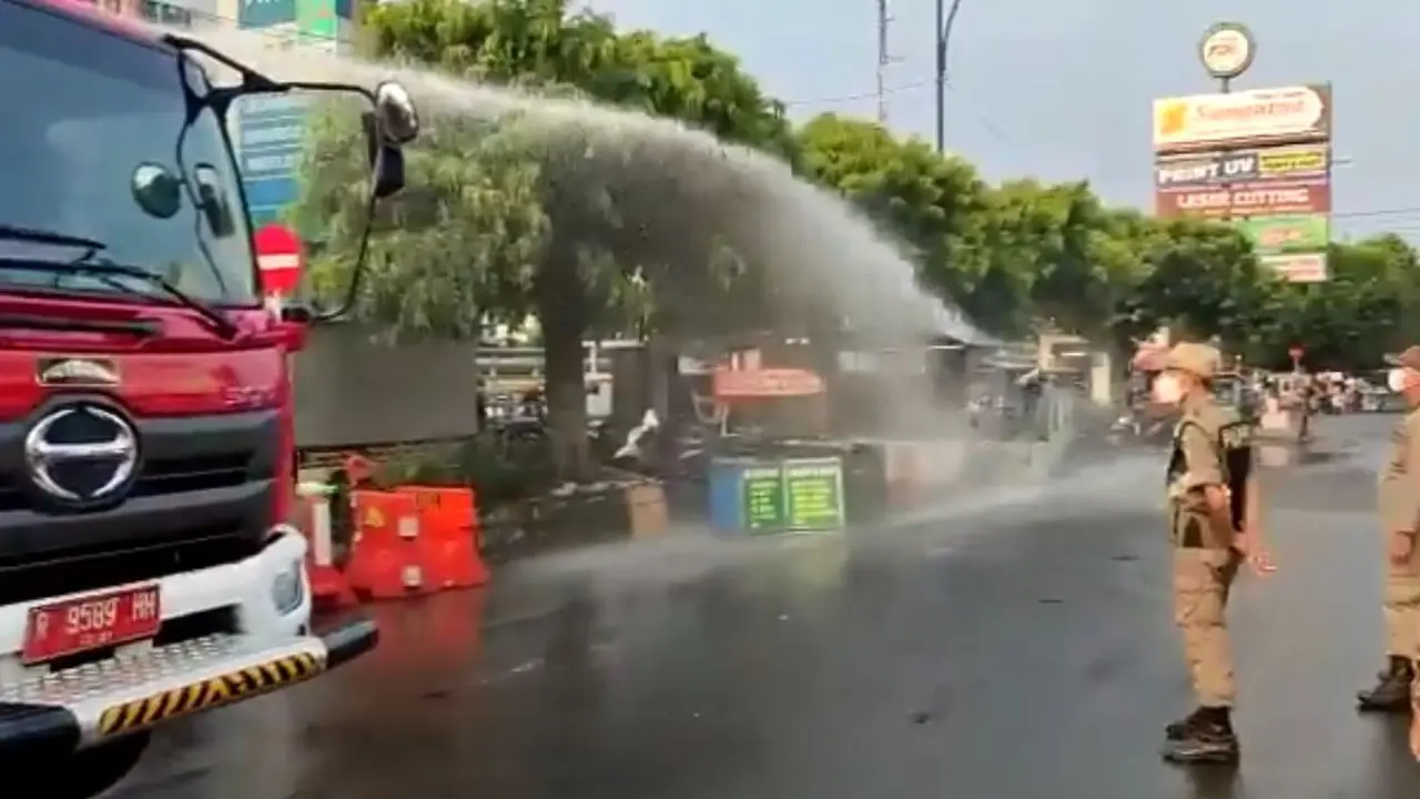 Satpol PP menyemprot lapak pedagang kaki lima (PKL) di Purwokerto, Banyumas, Jawa Tengah. (Foto: Liputan6.com/Tangkapan Layar video)