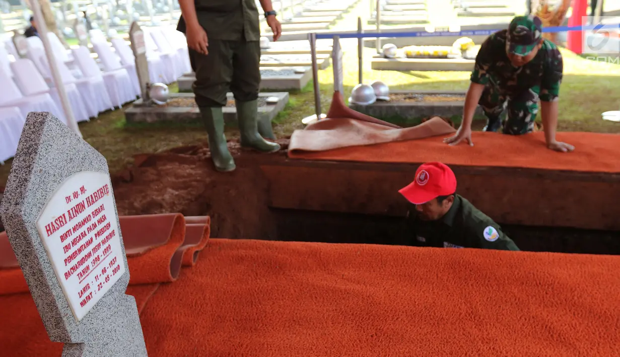 Pekerja menggali makam Presiden ke-3 RI BJ Habibie di TMP Kalibata, Jakarta, Kamis (12/9/2019). Makam Habibie bersebelahan dengan sang istri tercinta, Ainun Habibie. (Liputan6.com/Herman Zakharia)
