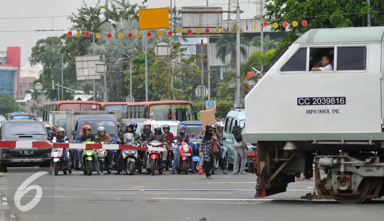  Sejumlah kendaraan menunggu kereta commuterline di perlintasan sebidang Stasiun Pasar Seen, Jakarta, (13/9). Ditjen Perkeretaapian Kemenhub akan menutup perlintasan sebidang di Jalan Letjen Soeprapto, Jakarta Pusat. (Liputan6.com/Gempur M Surya)