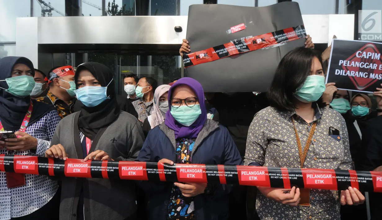 Pegawai KPK membentangkan garis line bertuliskan 'Dilarang Melewati Batas Pelanggar Etik' saat aksi di Lobi Gedung KPK, Jakarta, Jumat (6/9/2019). Dalam aksinya, mereka menolak Capim KPK jilid V yang dianggap bermasalah dan rencana pengesahan RUU KPK. (merdeka.com/Dwi Narwoko)