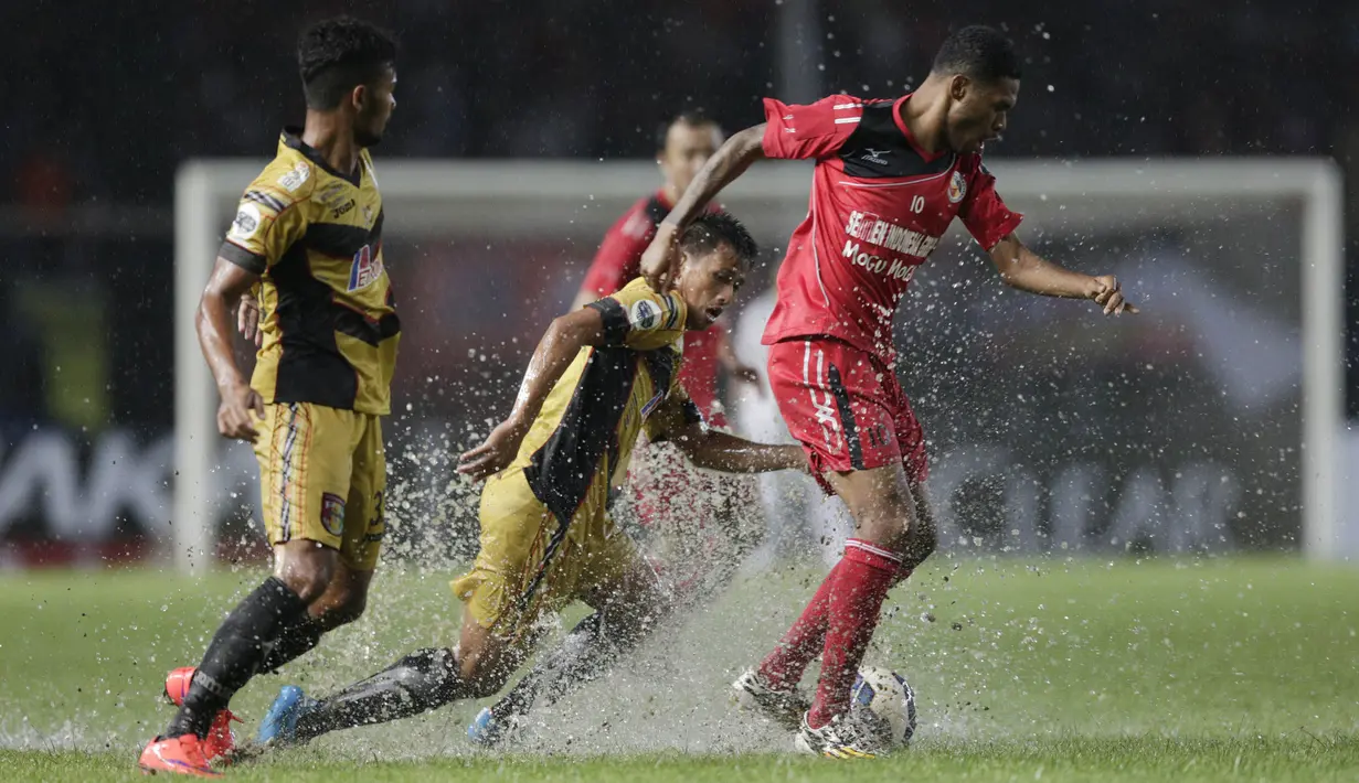 Gelandang Semen Padang, Vendry Mofu, berusaha melewati hadangan pemain Mitra Kukar, Hendra Ridwan, pada laga final Piala Jenderal Sudirman. Beberapa bagian lapangan tergenang karena hujan. (Bola.com/Vitalis Yogi Trisna)