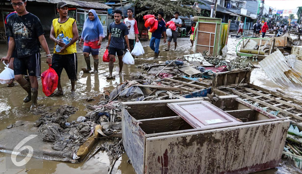 Sebuah lemari dan perabotan rumah tangga menumpuk di pinggir jalan usai banjir menggenangi komplek Pondok Gede Permai Jatiasih, Bekasi, Jumat (22/04). (Liputan6.com/Fery Pradolo)