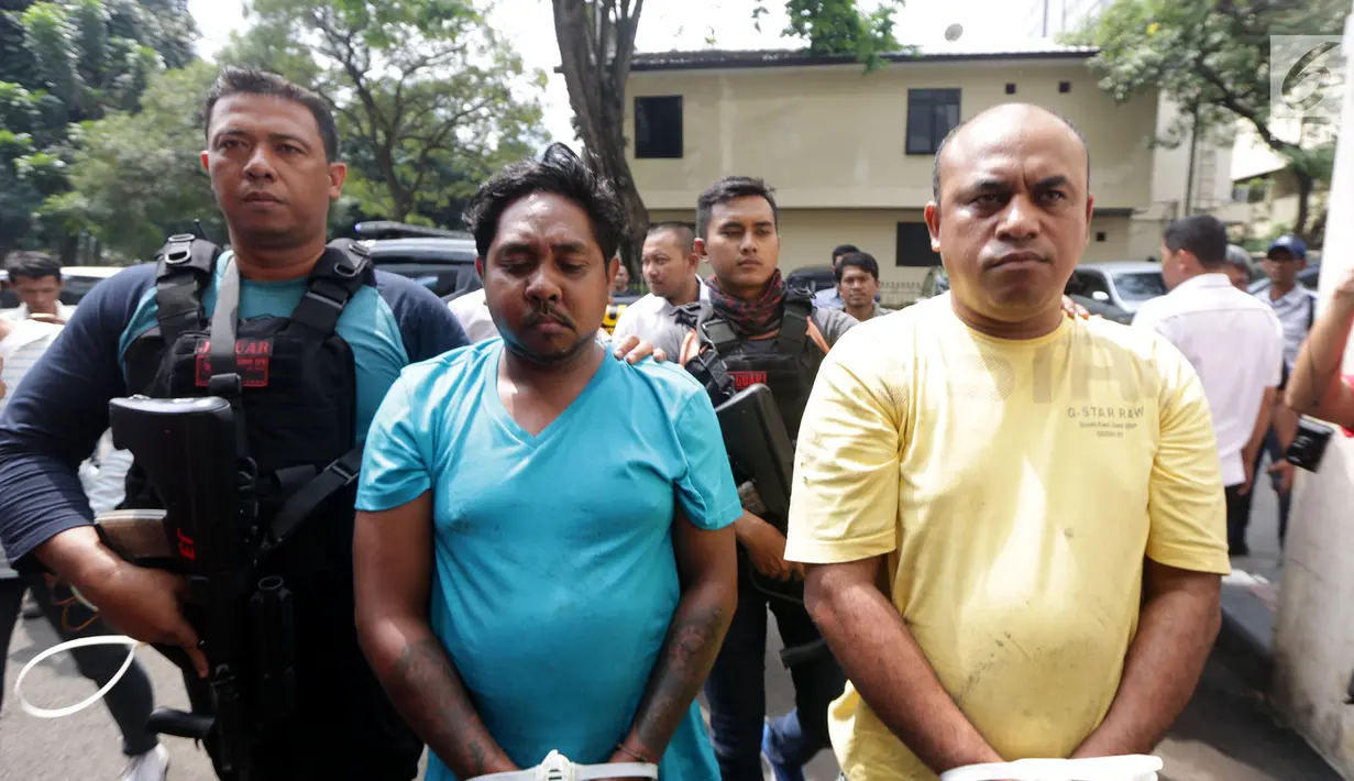 Pelaku pengeroyokan dan penganiayaan, Lauren Paliyama (tengah) dan Edwin Hitipeuw (kanan) dikawal oleh polisi saat dibawa ke Polda Metro Jaya, Jakarta (12/7). Kedua pelaku dibawa dengan posisi tangan diikat tali tis warna putih. (Liputan6.com/Pool)
