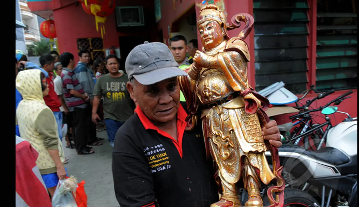 Petugas menyelamatkan patung dewa untuk dibawa ke lokasi yang lebih aman usai kebakaran yang melanda Wihara Dharma Bhakti pada Senin (2/3/2015) dini hari. (Liputan6.com/Faisal R Syam)