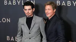 Sutradara Damien Chazelle (kiri) dan aktor Brad Pitt berpose untuk fotografer setibanya pada acara premiere film Babylon di Paris, Prancis, 14 Januari 2023. Brad Pitt melengkapi penampilannya dengan gelang putih dan melengkapi penampilannya dengan sepasang sepatu hitam. (AP Photo/Michel Euler)