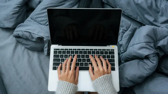 Ilustrasi Laptop di Atas Kasur