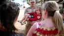 Seorang Angkatan Laut AS menggendong anaknya saat tiba di Camp Pendleton di Oceanside, California, AS, Kamis (11/5). Unit Ekspedisi Kelautan 11  telah menjalani tugas ke sejumlah negara selama 7 bulan. (AFP/ Sandy Huffaker)