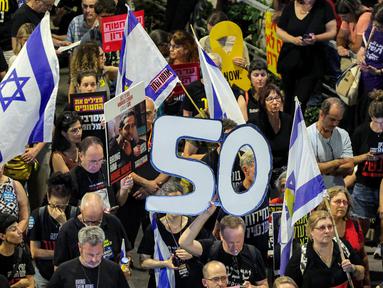 Seorang demonstran memegang angka "50", yang merujuk pada jumlah sandera yang masih berada di Jalur Gaza sejak serangan 7 Oktober 2023 oleh milisi Hamas, selama protes anti-pemerintah di luar markas besar Kementerian Pertahanan Israel di Tel Aviv pada 28 Juni 2025. (Jack GUEZ/AFP)