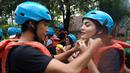 Krisshatta Luis Aveiro (kiri) dan Hilda Vitria Khan, memakai helm sebagai salah satu perlengkapan arung jeram sebelum berpetualang di Sungai Cicatih, Sukabumi, Sabtu (12/12/2015). (Bola.com/Arief Bagus)