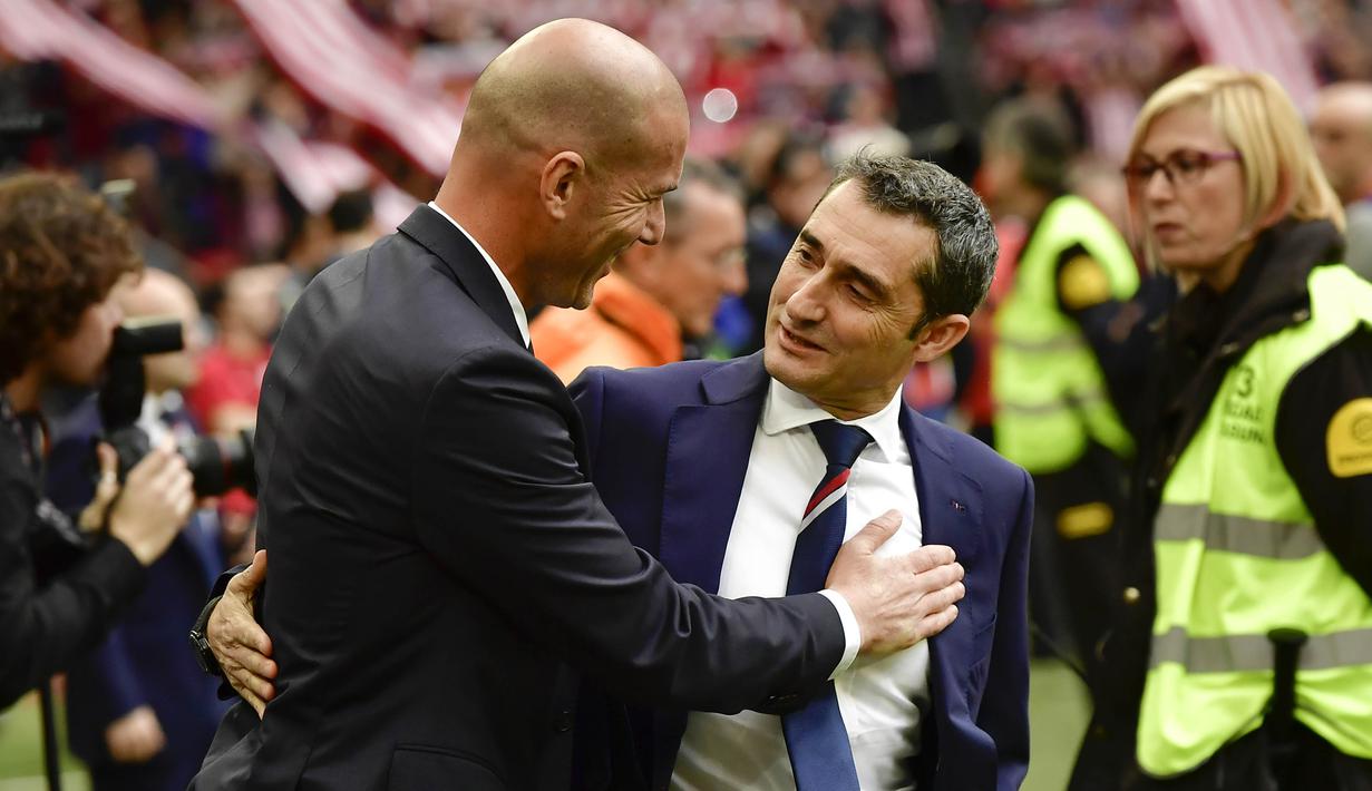 Pelatih Real Madrid, Zinedine Zidane, menyapa pelatih Athletic Bilbao, Ernesto Valverde. Tambahan tiga poin membuat Real Madrid nyaman di puncak klasemen La Liga dengan nilai 65 dari 26 laga. Unggul dua poin dari Barcelona. (AP/Alvaro Barrientos)