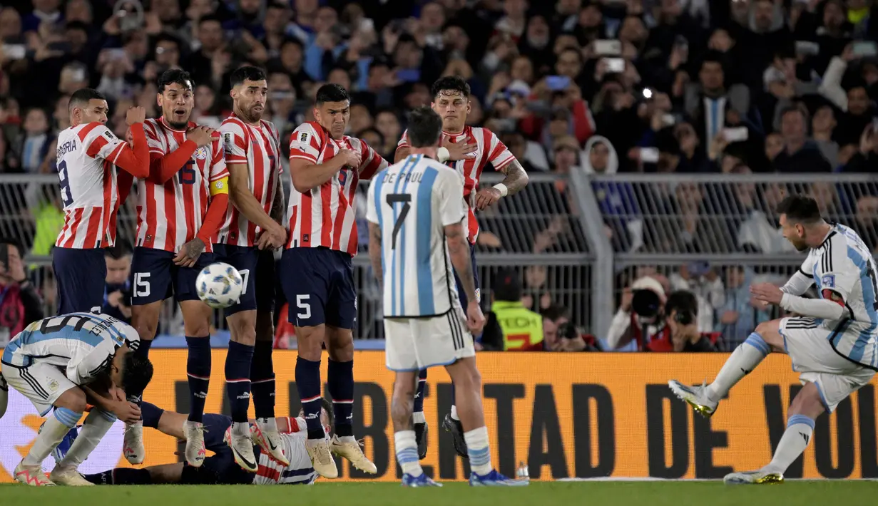 Pemain Timnas Argentina, Lionel Messi (kanan), menendang bola tendangan bebas ke gawang Paraguay dalm pertandingan Kualifikasi Piala Dunia 2026 zona CONMEBOL yang berlangsung di Stadion Mas Monumental, Jumat (13/10/2023) pagi WIB. Walaupun hanya bermain setengah jam lebih, Messi tetap memberikan ancaman bagi Paraguay. (AFP/Juan Mabromata)