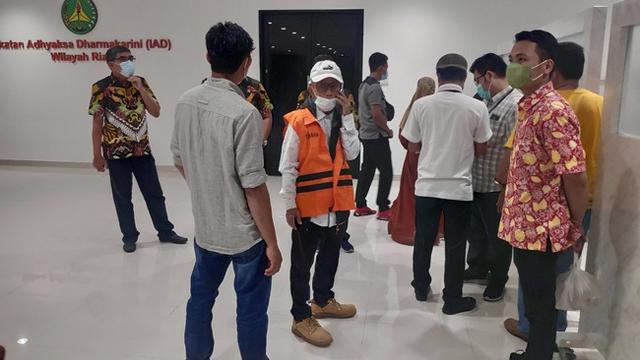 <span>Tersangka korupsi RSUD Bangkinang (pakai rompi oranye) saat menunggu petugas Kejati Riau untuk dibawa ke mobil tahanan. (Liputan6.com/M Syukur)</span>