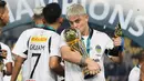 Pemain PSIM Yogyakarta, Rafinha mencium trofi Pegadaian Liga 2 2024/2025 setelah timnya berhasil menang atas Bhayangkara FC dalam laga final yang berlangsung di Stadion Manahan, Solo, Jawa Tengah, Rabu (26/02/2025). (Bola.com/Abdul Aziz)