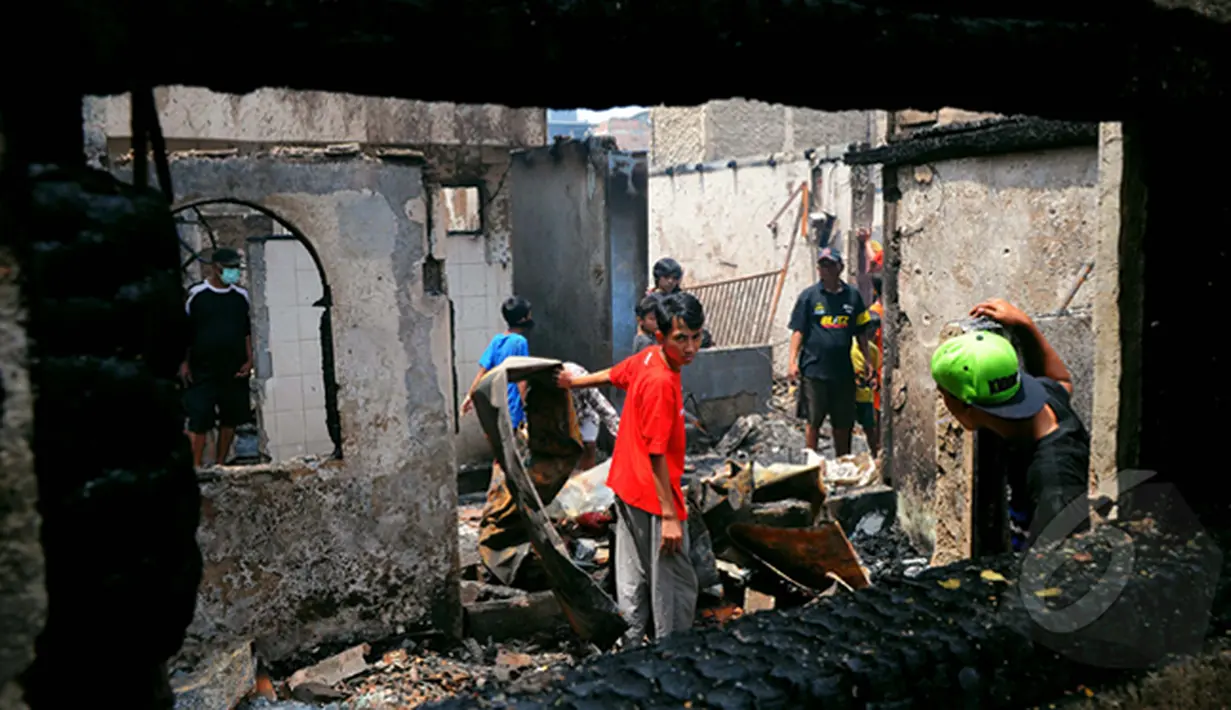 Sejumlah warga mengangkut puing sisa kebakaran di Karang Anyar, Sawah Besar, Jakarta, Selasa, (24/2/2015). Kebakaran yang melanda 14 Rukun Tetangga (RT) ini menyebabkan 2.000 warga kehilangan tempat tinggal. (Liputan6.com/Faisal R Syam)