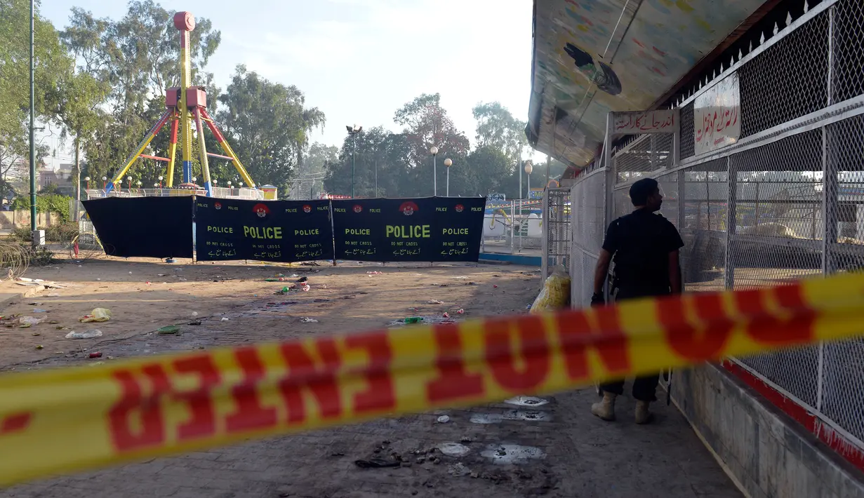 Petugas polisi Pakistan berjaga di lokasi bom bunuh diri di taman Gulshan e Iqbal Park di Lahore, Pakistan, Senin (28/3). Korban tewas akibat ledakan bom tersebut mencapai sekitar 69 orang. (AFP/ARIF ALI)