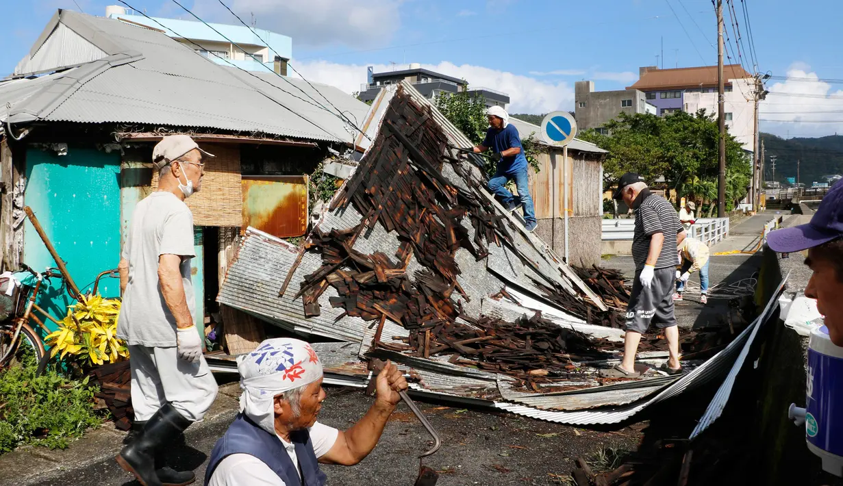 Topan Haishen di Jepang: Warga memperbaiki atap yang rusak akibat angin kencang menyusul topan Haishen di Amami, prefektur Kagoshima, barat daya Jepang, Senin (7/9/2020). Topan kuat kedua yang melanda wilayah itu dalam sepekan ini menyebabkan korban terluka dan bangunan rusak. (Kyodo News via AP)