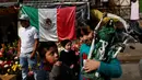 Seorang bocah membawa patung Santa Muerte atau The Saint of Death saat merayakan tahun baru di Meksiko, Minggu (1/1/2017). Warga Meksiko percaya jika berdoa kepada Santa Muerte akan membawa keberuntungan. (REUTERS/Carlos Jasso)