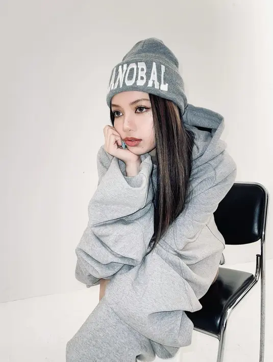 Dengan memakai full makeup, Lisa berpose duduk dengan mengenakan oversized hoodie abu-abu dan kaus kaki putih setinggi lutut. Ia lengkapi penampilannya dengan beanie hat abu-abu. Foto: Instagram.