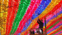Pengunjung memasang kartu harapan di salah satu lampion di Jogye Temple jelang perayaan ulang tahun Buddha, Seoul, Rabu (12/4). Di Negeri Ginseng ini, ulang tahun Buddha dirayakan dengan menggelar ‘Lotus Lantern Festival’. (AFP PHOTO / JUNG Yeon-Je) 