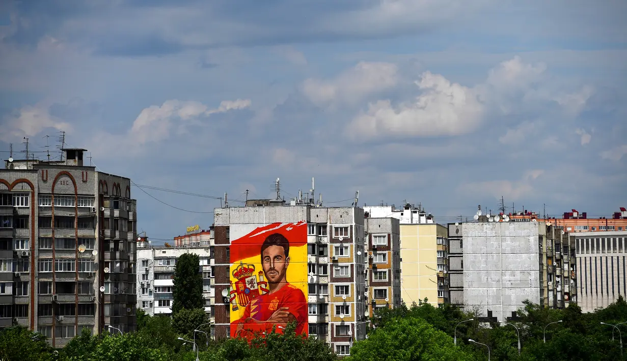 Sebuah mural raksasa begambar bek Spanyol Sergio Ramos terlihat di sebuah bangunan perumahan di Krasnodar, Rusia, Rabu (6/6). Ramos mendapat sambutan hangat di Krasnador. (Pierre-Philippe MARCOU/AFP)