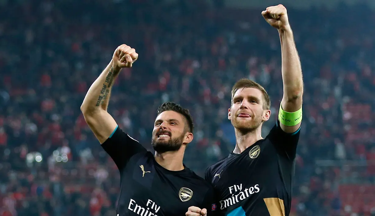 Olivier Giroud merayakan selebrasi dengan rekan setimnya Per Mertesacker usai mencetak hattrick melawan Olympiakos di Stadion Georgios Karaiskakis, Piraeus, Yunani  (9/12). Arsenal menang atas Olympiakos dengan skor 3-0. (Reuters/Andrew Couldridge)