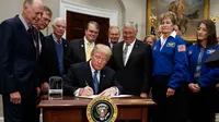 Presiden AS, Donald Trump menandatangani dokumen kebijakan untuk mengirim astronot AS kembali ke bulan dan Mars, di Ruang Roosevelt Gedung Putih, di Washington (11/12). (AP Photo/Evan Vucci)