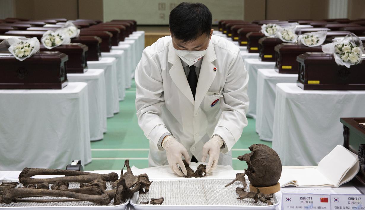 Anggota MND Agency for KIA Recovery and Identification (MAKRI) Korea Selatan menata jenazah tentara China yang tewas dalam Perang Korea di Incheon, Korea Selatan, Rabu (1/9/2021). Korea Selatan memulangkan 109 tentara China yang tewas dalam Perang Korea. (Jeon Heon-kyun/Pool Photo via AP)