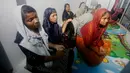 Muslim Rohingya duduk di balik jerusi besi di sebuah kantor polisi di Provinsi Satun, Thailand Selatan pada 11 Juni 2019. Sebanyak 65 Muslim Rohingya ditemukan di sebuah kapal yang nyaris karam di bagian selatan negara itu. (Department of National Parks Wildlife and Plant Conservation via AP)