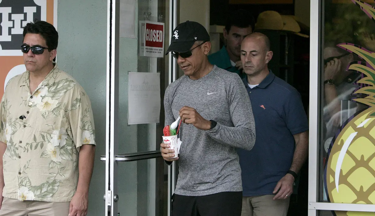 Presiden AS Barack Obama berjalan usai usai membeli es disebuah toko minuman dengan keluarga dan teman-teman selama liburan Natal di Kailua, Hawaii, (27/12/2015). (REUTERS/Hugh Gentry)