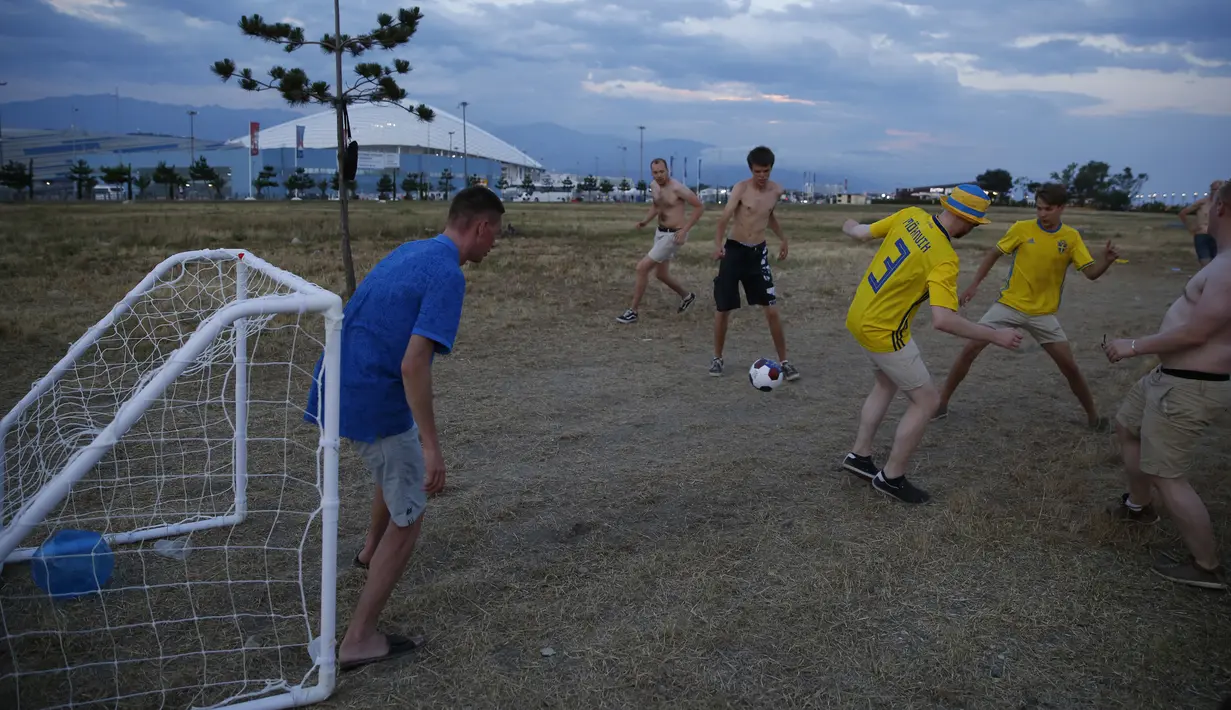 Sejumlah suporter Swedia bergembira bermain bola di sekitar Pantai Sochi, Jumat (22/6/2018). Para suporter bersiap untuk menyaksikan laga Piala Dunia 2018 antara Swedia melawan Jerman. (AP/Rebecca Blackwell)