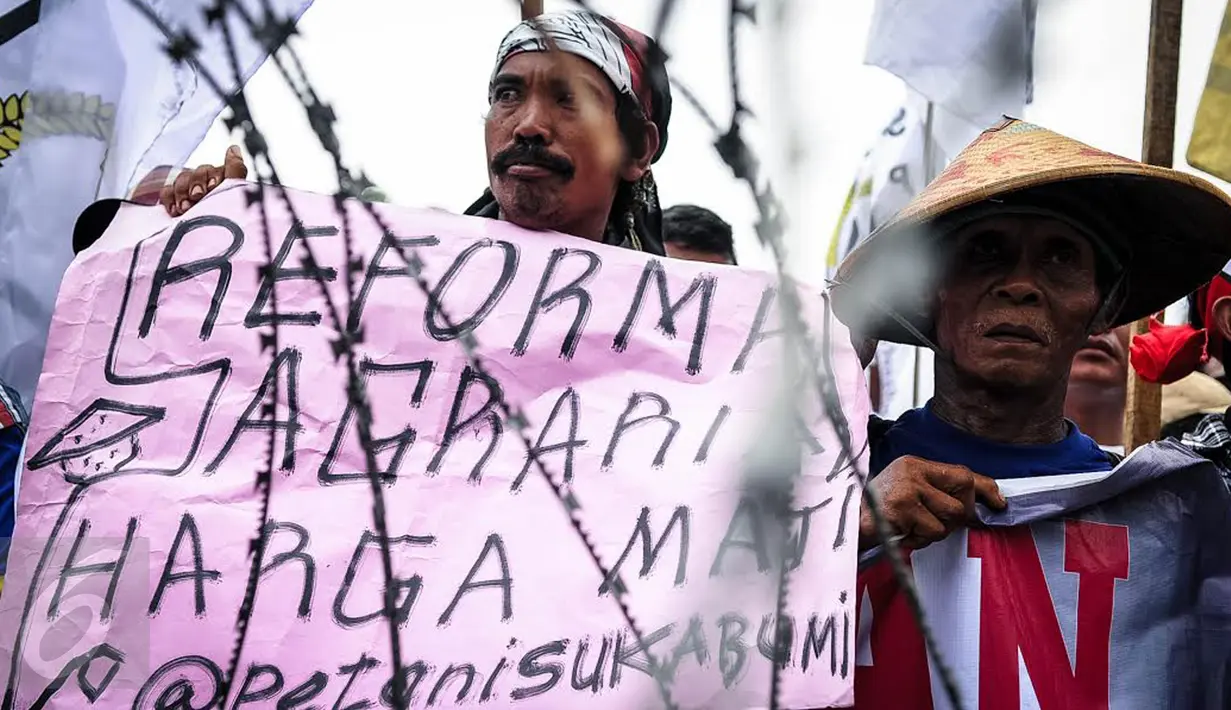 Massa yang mengatasnamakan petani dari berbagai provinsi menbentangkan poster saat menggelar demonstrasi di kawasan Medan Merdeka, Jakarta, Selasa (27/9). Aksi tersebut digelar dalam rangka memperingati Hari Tani Nasional. (Liputan6.com/Faizal Fanani)