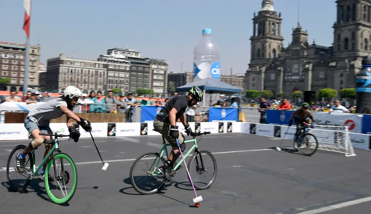 Peserta berebut bola sambil mengendarai sepedanya saat bermain Polo-Bike pada hari kedua World Bike Forum 2017 di Zocalo Square di Mexico City (20/4). Polo sepeda ini dimainkan oleh 3 orang dalam 1 timnya. (AFP Photo/Alfredo Estrella)