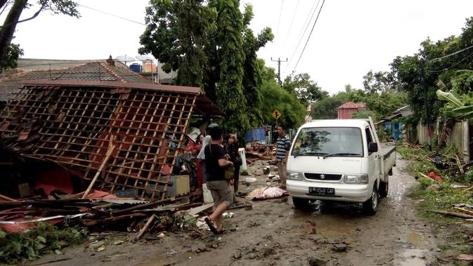 Warga memeriksa kerusakan rumah mereka setelah tsunami menerjang Pantai Carita, di perairan Banten, Minggu (23/12). Tsunami menerjang pantai di Selat Sunda, khususnya di daerah Pandenglang, Lampung Selatan, dan Serang. (SEMI / AFP)