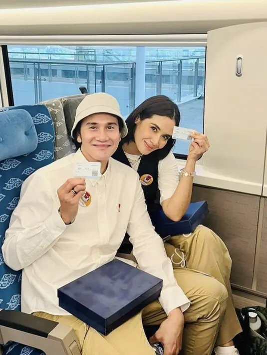 Vino G Bastian mengenakan kemeja putih panjang, dipadukan celana jogger coklat muda. Ia pun tampil dengan bucket hatnya. [@marshatimothy]