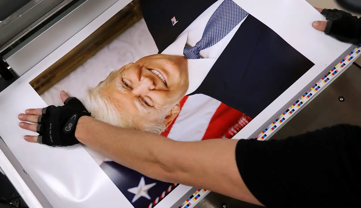 Pekerja menyelesaikan proses pembuatan foto Presiden Amerika Serikat Donald Trump di Washington DC (4/12). Ribuan foto resmi Donald Trump ini akan diedarkan ke lebih 1.600 kantor federal di seluruh dunia. (Chip Somodevilla/Getty Images/AFP)