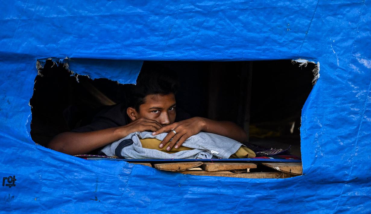 Dalam foto yang diambil pada 19 Juni 2024 ini, seorang pria beristirahat di tempat penampungan pengungsi Rohingya di pantai Kulee, di Kabupaten Pidie, provinsi Aceh. (CHAIDEER MAHYUDDIN/AFP)