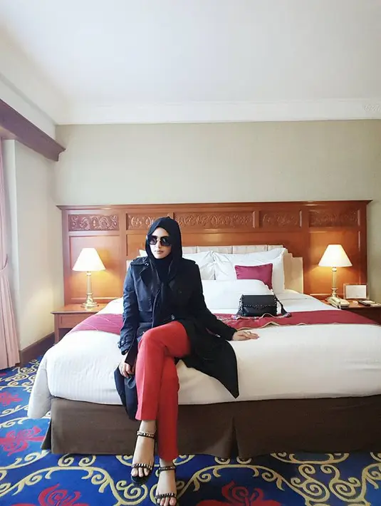Nah kalau yang satu ini Yulia tampak sedang di kamar hotel. Tampilannya juga memukau banget. Ia memaka celana panjang merah dengan atasan hitam yang dibuat senada dengan heelsnya. (Doc. Facebook)