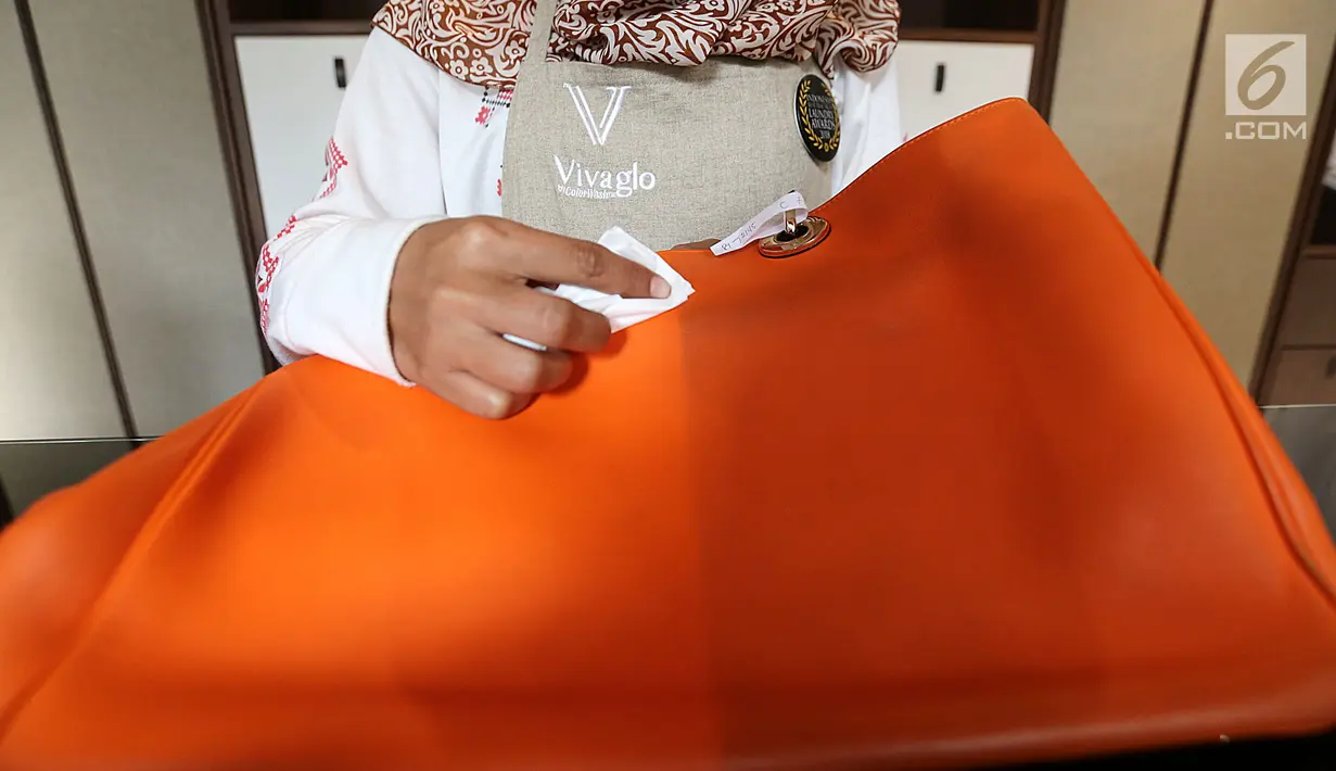 Pekerja membersihan tas dengan cairan berbahan solvent intense yang ramah lingkungan di laundry dan dry cleaning Vivaglo, Jakarta, Rabu (9/5). (Liputan6.com)