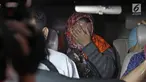 Panitera Pengganti PN Tangerang, Tuti Atika menutup wajah usai diperiksa di gedung KPK, Jakarta, Selasa (13/3). Tuti Atika berstatus tersangka bersama Hakim PN Tangerang Wahyu Widya Nurfitri dan dua pengacara. (Liputan6.com/Herman Zakharia)