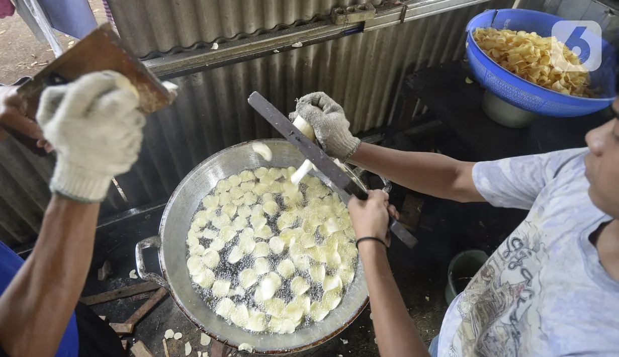 Pekerja menyerut dan langsung menggoreng keripik singkong rumahan di Kampung Kopi, Gunung Sindur, Bogor, Jawa Barat, Selasa (8/9/2020). Camilan yang dijual dengan harga Rp 8 ribu hingga Rp 50 ribu tergantung rasa tersebut banyak diminati warga di masa pandemi. (merdeka.com/Dwi Narwoko)