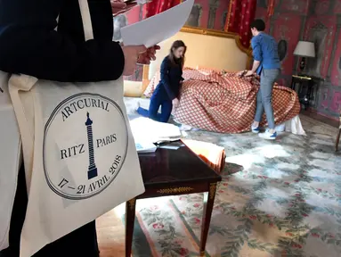 Pekerja menyiapkan tampilan ruangan Suite Imperiale dari Hotel Ritz sebelum dipamerkan di rumah lelang Artcurial, Paris, Rabu (11/4).  Hotel legendaris di Paris tersebut melelang beberapa barang ikoniknya pada 17 April mendatang. (GERARD JULIEN/AFP)