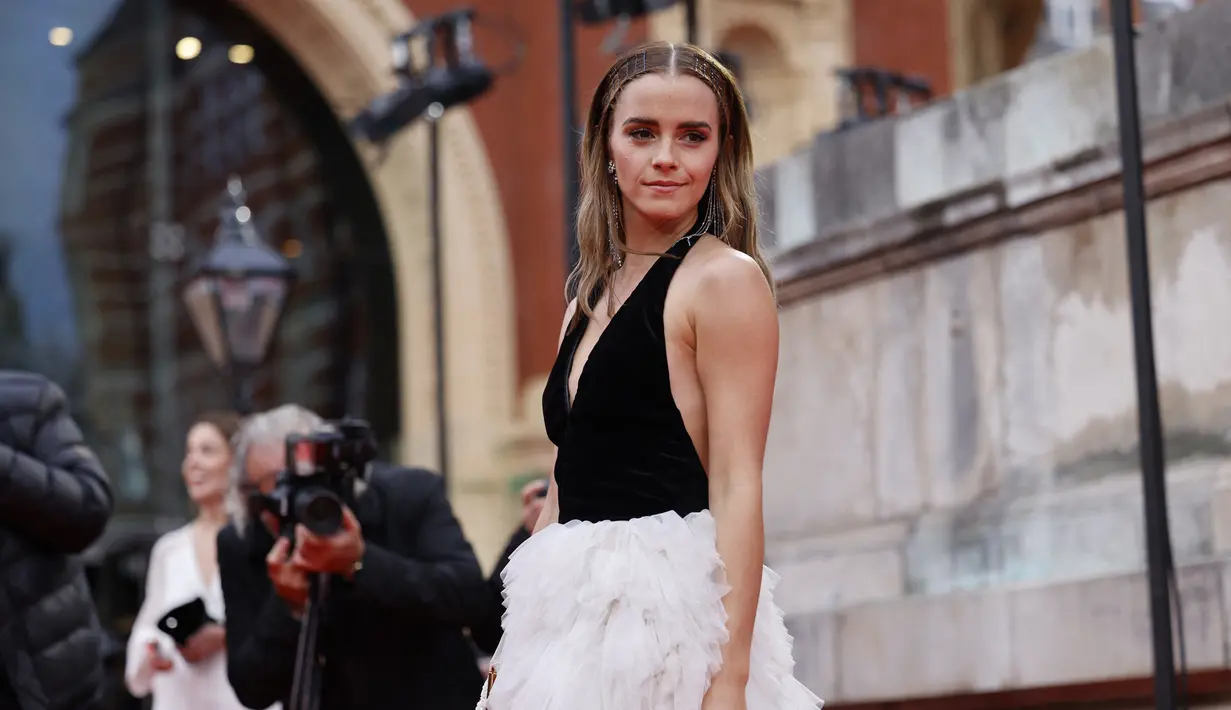 Aktris Inggris Emma Watson berpose di karpet merah saat tiba di BAFTA British Academy Film Awards di Royal Albert Hall, di London (13/3/2022). Emma Watson melengkapi ansambel sensasionalnya dengan sepasang anting rumbai perak mewah dan serangkaian cincin perak. (AFP/Tolga Akmen)
