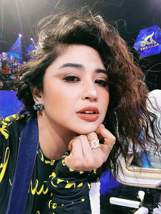 Rambut Dewi Perssik yang asli lurus dan tebal dikenal begitu indah. Ketika diubah menjadi keriting terurai pun akan tampak lebih memukau. Bintang film Tali Pocong Perawan ini juga tak ragu mewarnai bagian bawah rambutnya dengan warna coklat. Penampilannya ini makin memesona. (Liputan6.com/IG/@dewiperssik9)